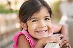 A young child, a girl smiling at the camera.