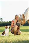 Close-up portrait of a young woman with her Haflinger horse and her Kooikerhondje puppy in summer, Upper Palatinate, Bavaria, Germany