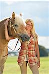 Close-up portrait of a young woman standing beside her Haflinger horse in summer, Upper Palatinate, Bavaria, Gemany