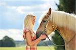 Close-up portrait of a young woman standing beside her Haflinger horse in summer, Upper Palatinate, Bavaria, Germany