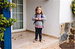 3 year old girl with her backpack stands in the doorway, Spain