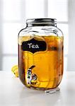 Glass jar with tap dispenser containing fresh lemon tea drink