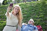 Young couple taking selfie with smartphone in park