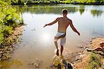 Rear view of young man stepping into canal, Delaware Canal State Park, New Hope, Pennsylvania, USA