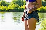 Cropped shot of young woman smoking cigarette on canal bank, Delaware Canal State Park, New Hope, Pennsylvania, USA