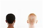 Rear view studio portrait of young couple's cropped hair