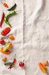 Selection of summer chilli peppers on an ivory linen surface