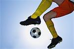 Football player kicking ball in mid-air