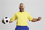 Football player in a yellow and blue uniform standing against white background