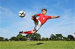 Soccer Player Kicking The Ball In Mid-Air