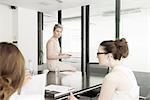 Three young businesswomen at meeting in conference room