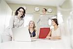 Four businesswomen looking at laptop