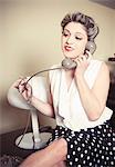 Portrait of young woman wearing vintage clothes and talking on vintage phone