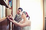 Young vintage couple browsing books on shelf