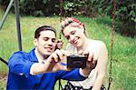 Young vintage couple taking selfie camera in garden