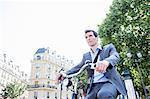 Mid adult businessman commuting on bicycle, Paris, France