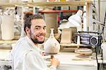 Male potter working on vase in ceramic workshop