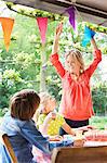 Mother chatting with children and putting up bunting