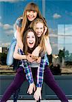 Three young women stacked on top of each other in city