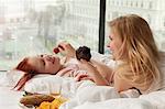 Young women having breakfast in bed, Vienna, Austria