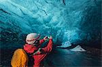 Man photographing ice cave with smartphone, Vatnajokull Glacier, Vatnajokull National Park, Iceland