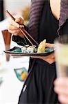 A woman eating sushi in a restaurant