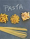 Various different types of pasta on a slate sheet