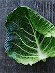 A savoy cabbage leaf on a weathered wooden surface