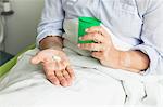 Patient in hospital holding cup and pills