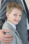 Boy smiling beside father, close up