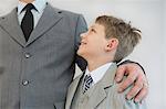 Father holding his son in his arm against white background, smiling