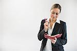 Businesswoman in black suit holding notebook and pen, smiling
