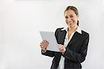 Portrait of businesswoman in black suit using digital tablet, smiling