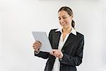 Businesswoman in black suit using digital tablet, smiling