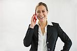 Businesswoman in black suit talking on smart phone, smiling