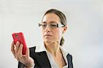 Businesswoman in black suit using smart phone