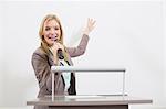 Businesswoman at speakers desk in auditorium