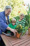 Grandmother repotting plant with her grandsons