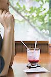 Young Japanese woman with raspberry soda in a cafe