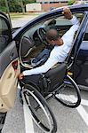 Man who had Spinal Meningitis entering his car with his wheelchair