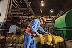 Engineer in electric power plant inspecting condenser piping