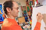 Man with Aspergers drawing his outline for his painting in his art studio