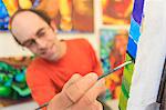 Man with aspergers painting in his art studio