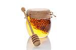 Honey in glass jar with wooden dipper and honey comb isolated on white background. Organic bee honey.