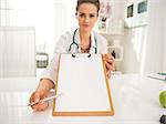 Closeup on doctor woman pointing on clipboard