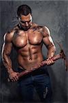 Muscular man holding pickaxe