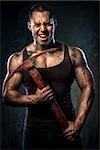 Muscular man holding pickaxe