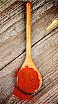 Crushed Paprika in Wooden Spoon on Rustic Wooden background. Top View