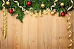 Christmas background with fresh firtree, baubles and ribbons on wood - horizontal