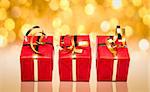 Photo of three red and gold gift boxes with out of focus lights on a golden background